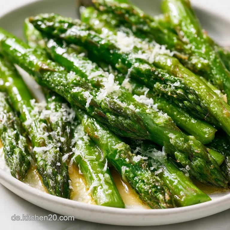 Goldbraun gebratener gr&uuml;ner Spargel, kunstvoll auf einer dunklen Platte platziert, erg&auml;nzt durch frische Kr&auml;uter.